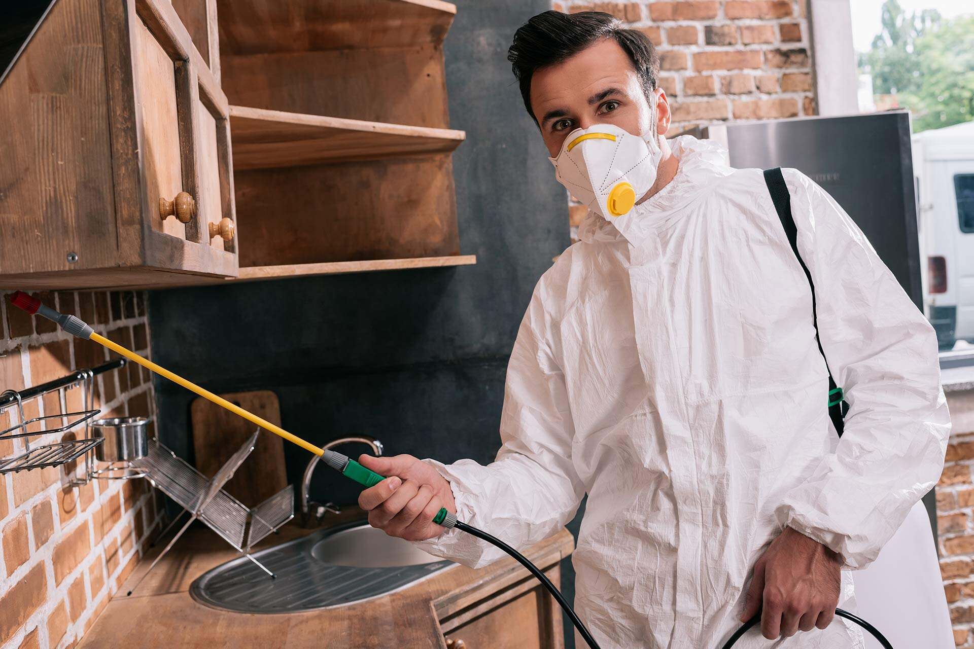 pest-control-worker-spraying-pesticides-under-shel-2024-11-18-21-25-02-ENDQ9EW